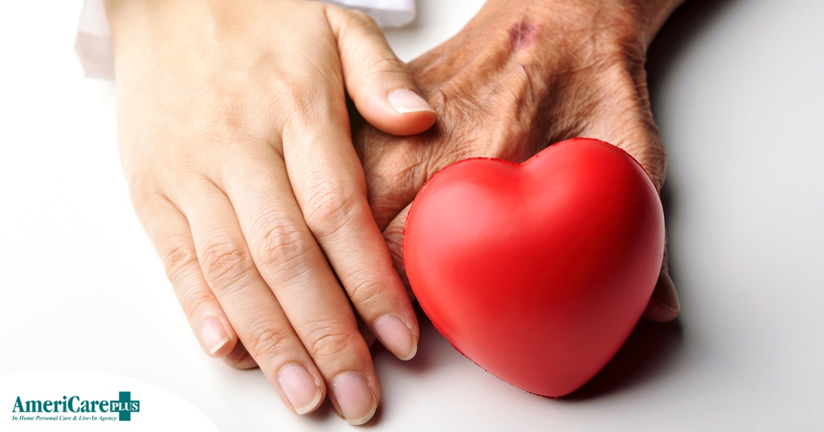 An old hand and a young hand with a heart represent caregiving.